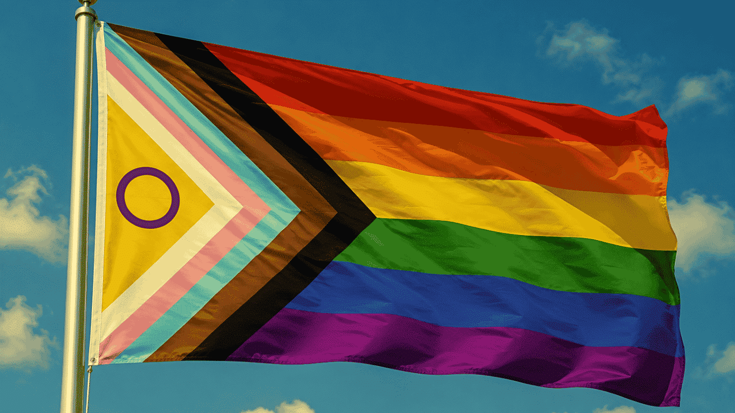 lgbtqqip2saa full acronym progress pride flag flowing in blue sky with intersex inclusive colors